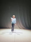 Actor standing in performance space reading script.