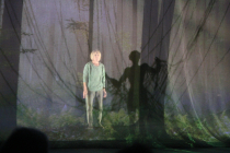 Performer in forest with digital cables figure behind